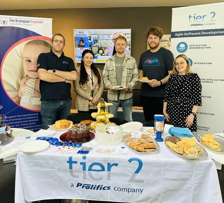 btc centre client tier 2 stand behind table with baked goods for sale at charity fundraiser